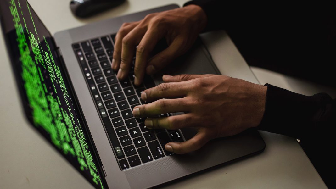 Man on a laptop with code on the screen