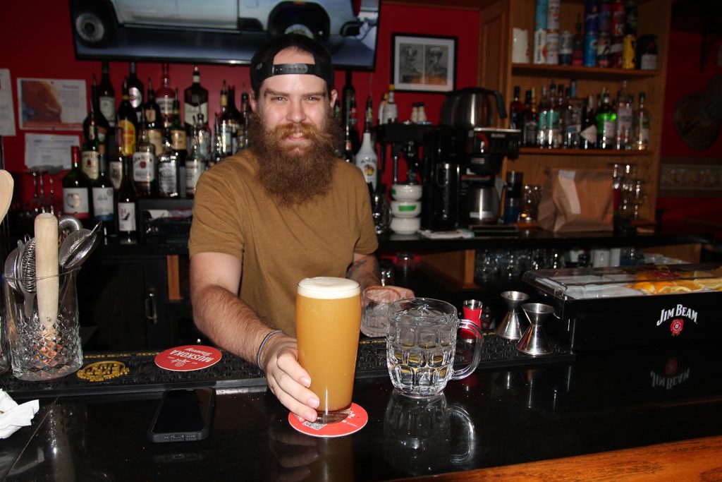 Bartender offering a perfect pour of beer on tap